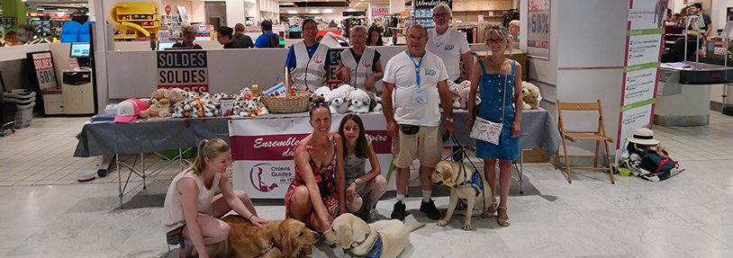 Personnes avec chien dans un magasin devant un stand