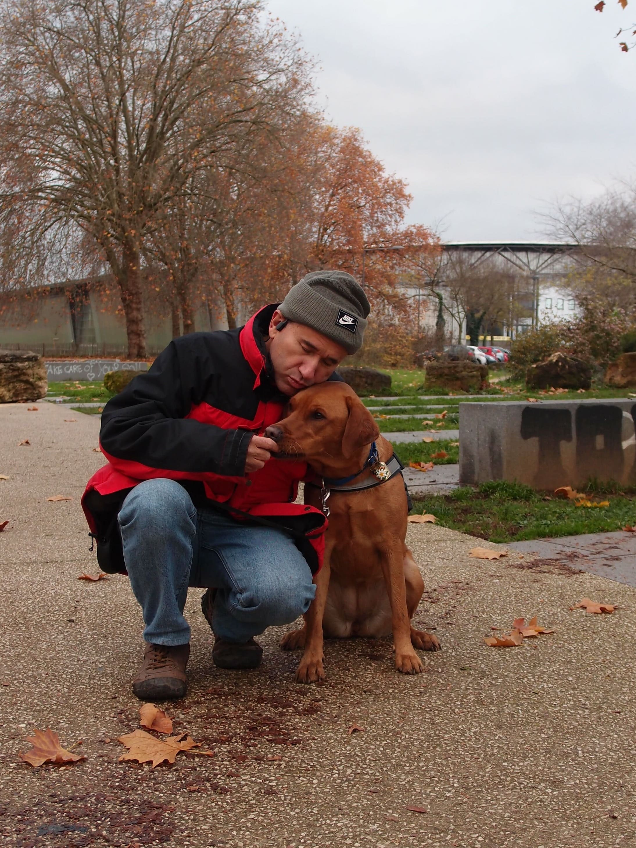 Homme accroupi regardant un chien